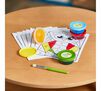 Washable Spill Proof Paint Kit Activity Pages and Paint on table with yellow paint cup tipped on side.