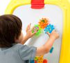Deluxe Magnetic Double-Sided Easel. Child playing with gears on the white board. 