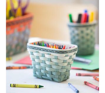 Crayola x Longaberger small crayon basket, pine green, on table with art supplies.